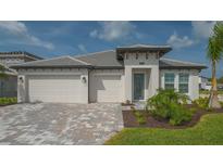 Beautiful single-story home with a three-car garage, modern architecture and a well-manicured lawn at 2015 Bolsena St, Nokomis, FL 34275