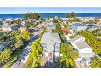 Beautiful aerial view of a two-story home near the ocean with lush green landscaping and a grey roof at 2300 Avenue B, Bradenton Beach, FL 34217