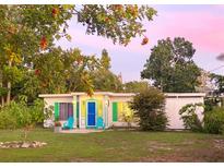 Charming single-story home featuring a blue door, green shutters, and lush landscaping, perfect for enjoying outdoor living at 2830 Gypsy St, Sarasota, FL 34231