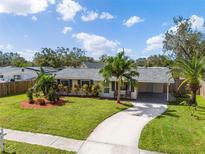 Charming single-story home featuring a well-maintained lawn, driveway, and lush tropical landscaping at 3458 Lalani Blvd, Sarasota, FL 34232