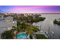 Aerial view of waterfront home with a pool, dock, and lush tropical landscaping at 4607 5Th Ne Ave, Bradenton, FL 34208
