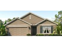 Charming single-story home with beige siding, a two-car garage, and manicured landscaping at 4611 Dusky Dawn Ln, Palmetto, FL 34221