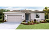 Charming single-story home showcasing a two-car garage, stone accents, manicured lawn, and welcoming front entrance at 5631 Silver Moonlight Dr, Palmetto, FL 34221