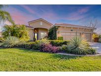 Charming single-story home with lush landscaping, tile roof, and attached three-car garage at 6600 Horned Owl Pl, Sarasota, FL 34241