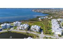Stunning aerial view of waterfront condos with lush landscaping and serene pond, offering luxurious coastal living at 7910 34Th W Ave # 203, Bradenton, FL 34209