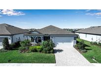 Charming single-story home featuring a well-maintained lawn, stone driveway, and an attached two-car garage at 8726 Backshore Ln, Parrish, FL 34219