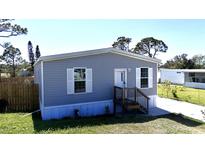 Charming single-story home with gray siding, white trim, front door, and landscaped front yard at 11337 Pineapple Rd, Punta Gorda, FL 33955