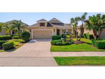Charming single-story home featuring a manicured lawn, landscaping, and a two-car garage at 12140 Whisper Lake Dr, Bradenton, FL 34211