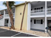 Condo exterior showing the building's facade, balconies, and landscaping with palm trees, and parking area at 1531 Pleasant Rd # H-3, Bradenton, FL 34207