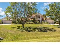 Stunning two-story home with lush green lawn, mature trees, and a charming front porch at 17809 Howling Wolf Run, Parrish, FL 34219
