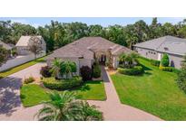 Beautiful home featuring a lush landscaped front yard, brick walkway, and inviting entrance at 2114 147Th E Ct, Bradenton, FL 34212