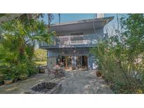 A cozy backyard patio with a fire pit and outdoor seating, surrounded by lush tropical landscaping and a two story home at 2230 Myakka Rd, Sarasota, FL 34240