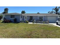 Charming single-story home with a well-maintained front yard and a cozy seating area on the porch at 22337 Olean Blvd, Port Charlotte, FL 33952