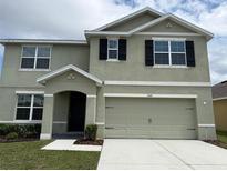 Inviting two-story home featuring a well-maintained lawn and a two-car garage at 2409 Sand Gables Trl, Bradenton, FL 34208