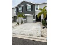 Charming townhome featuring a two-car garage, manicured landscaping, and neutral color scheme at 2846 Midnight Pearl Dr, Sarasota, FL 34240