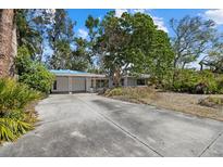 Traditional single-story home with a long driveway and mature trees at 3466 Tanglewood Dr, Sarasota, FL 34239