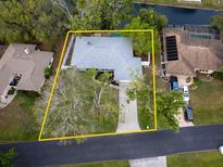 An aerial view showcases this single-Gathering home with a swimming pool and mature landscaping, outlined in yellow at 4453 Meadow Creek Cir, Sarasota, FL 34233
