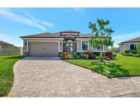 Beautiful one-story home featuring a manicured lawn and brick-paved driveway leading to a two-car garage at 6620 35Th E Ct, Sarasota, FL 34243