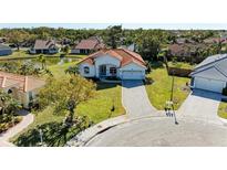 Stunning aerial view of a property with a red tile roof, surrounded by lush landscaping and a serene pond at 7102 42Nd E Ct, Sarasota, FL 34243