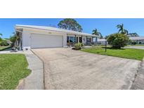 Charming single-story home with a two-car garage, well-manicured lawn, and a spacious concrete driveway at 1325 Bottlebrush Dr, Bradenton, FL 34208