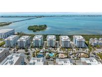 Stunning aerial view of the condo complex with pool, landscaping and beautiful waterfront views at 384 Aruba Cir # 103, Bradenton, FL 34209