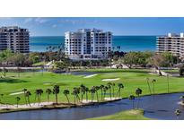 Stunning view of the golf course and waterway with the white condo buildings in the background at 455 Longboat Club Rd # 407, Longboat Key, FL 34228