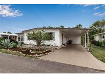 Charming home featuring a covered parking area, landscaped garden, and well-maintained lawn at 617 Cervina S Dr, Venice, FL 34285