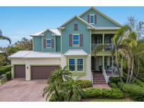 Charming two-story home with a metal roof, colorful shutters, a two-car garage, and beautifully landscaped yard at 8227 37Th Avenue W Cir, Bradenton, FL 34209