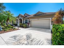 Charming single-story home with a well-manicured lawn, lush landscaping, and a spacious driveway leading to an attached two-car garage at 107 Wayforest Dr, Venice, FL 34292