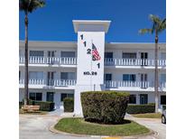 Condo building with palm trees, updated facade, and American flag waving, in a well-maintained community at 11251 80Th Ave # 305, Seminole, FL 33772