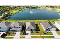 Beautiful single-Gathering home featuring lush green landscaping and a serene lake view at 12533 Night View Dr, Sarasota, FL 34238