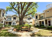 Charming townhouse community features mature landscaping and a welcoming outdoor seating area at 2409 Gun Flint Trl, Palm Harbor, FL 34683