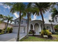 Charming two-story home with lush landscaping, a three-car garage, and an inviting arched entryway at 271 Petrel Trl, Bradenton, FL 34212