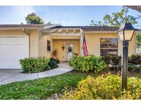 Charming home featuring a well-manicured yard, front door wreath, and American flag at 4058 Oakhurst Dr # 3174, Sarasota, FL 34233