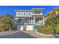 Charming blue two-story home with a brick driveway and white trim at 4941 Commonwealth Dr, Sarasota, FL 34242