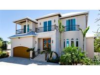 Beautiful two-story home with balconies, a wood door, and a three-car garage at 511 Bayview Dr, Holmes Beach, FL 34217