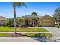 Charming single-story home with well-manicured lawn, mature trees, and a two-car garage at 5270 White Ibis Dr, North Port, FL 34287