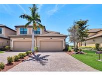 Charming two-story home featuring a paved driveway, two-car garage, and meticulously landscaped front yard at 6708 Grand Estuary Trl # 104, Bradenton, FL 34212