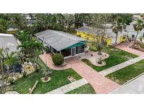 Charming home with a screened-in porch, brick pathway, lush landscaping, and inviting curb appeal at 710 Fox St, Longboat Key, FL 34228