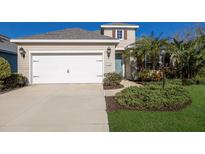 Charming home exterior with a well-maintained lawn and a two-car garage at 7742 Ridgelake Cir, Bradenton, FL 34203