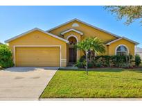 Charming yellow home with a well-maintained lawn and manicured landscaping at 3503 14Th E Ct, Ellenton, FL 34222