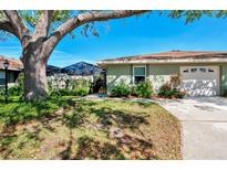 Charming one-story home with a well-manicured lawn, mature landscaping, and a screened pool enclosure at 4091 Center Pointe Pl # 40A, Sarasota, FL 34233