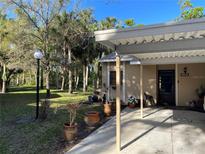 Charming single-story home features a covered carport, mature landscaping, and well-maintained front yard at 5013 Village Gardens Dr # 34, Sarasota, FL 34234