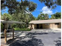 Single story home featuring mature landscaping, covered parking, and neutral exterior paint at 5013 Village Gardens Dr # 34, Sarasota, FL 34234