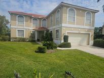 Elegant two-story home showcasing a tile roof, lush lawn and meticulously landscaped front yard, enhancing its curb appeal at 5121 Glade Fern Ct, Sarasota, FL 34238