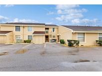 Tan two-story condo building with multiple units and reserved parking in a well-maintained complex at 6342 7Th W Ave # 6342, Bradenton, FL 34209