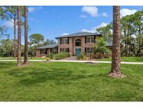 Spacious brick home with manicured lawn and lush landscaping, offering curb appeal at 7401 S Gator Creek Blvd, Sarasota, FL 34241