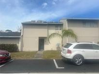 Two-story tan townhouse with a palm tree in the front yard at 965 Whitman Dr, Sarasota, FL 34243