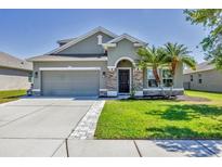 Charming single-Gathering home with a two-car garage, well-manicured lawn, and lush palm trees at 11037 77Th E St, Parrish, FL 34219