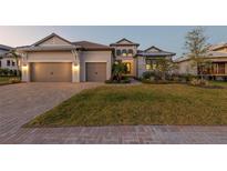 Charming two-story home with a well manicured lawn, brick driveway, and a three car garage at 1702 4Th St E E St, Palmetto, FL 34221